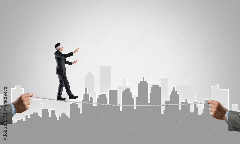 Business concept of risk support and assistance with man balancing on rope Business concept of risk support and assistance with man balancing on rope