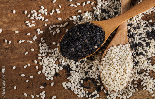 Fresh black and white sesame seeds in spoons