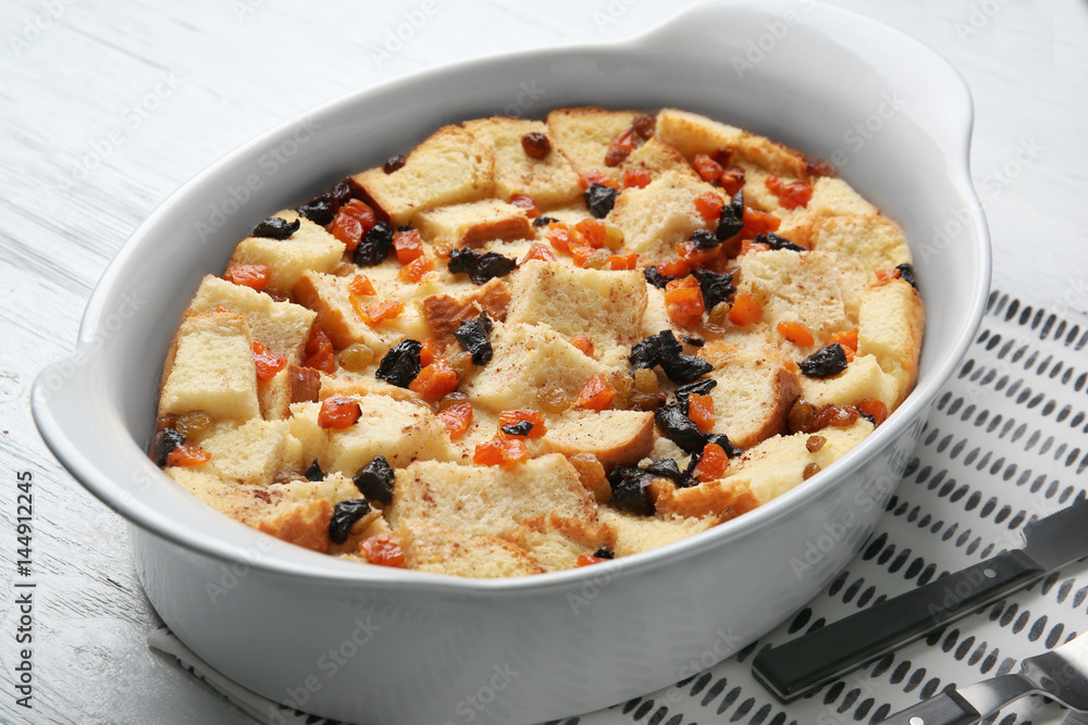 Freshly baked bread pudding in casserole dish on wooden table Freshly baked bread pudding in casserole dish on wooden table