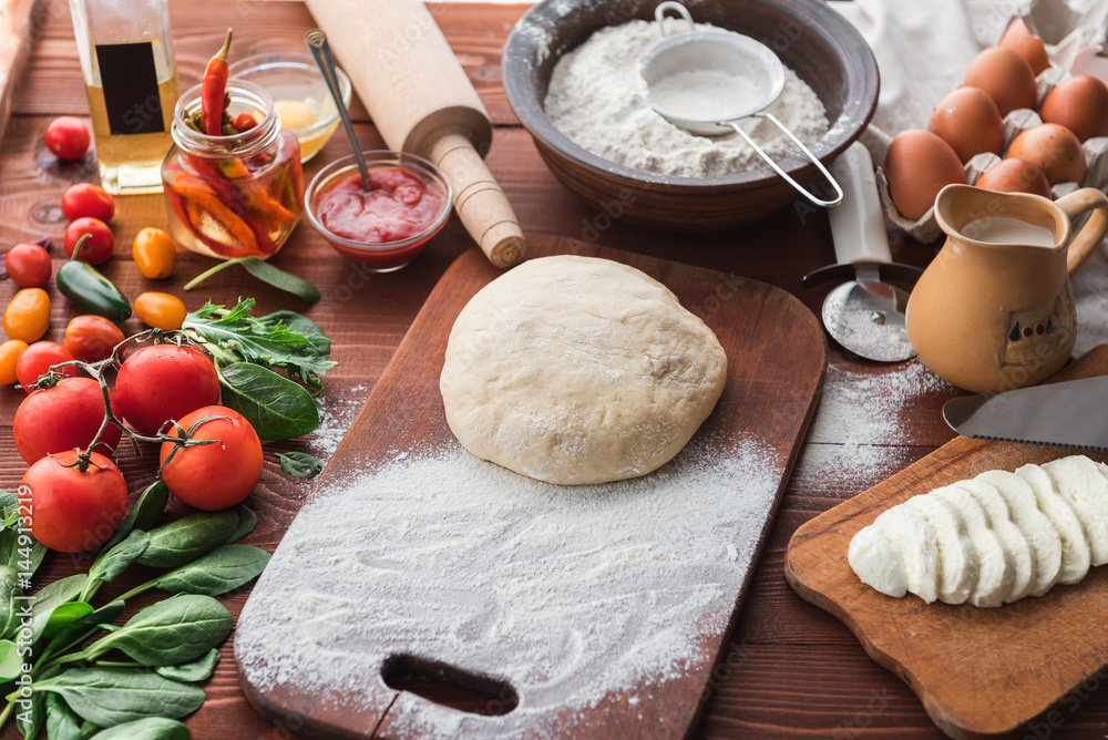 Fototapeta premium Step-by-step boss makes a pizza margarita. Dough and pizza ingredients