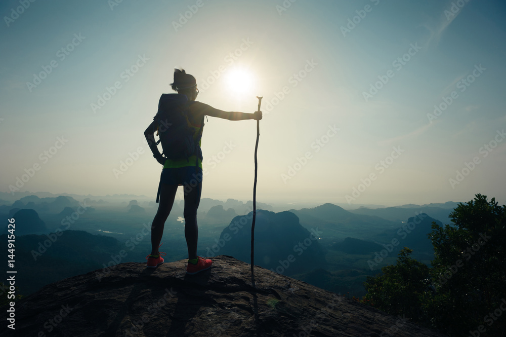 silhouette of woman backpacker hiking on sunrise mountain top