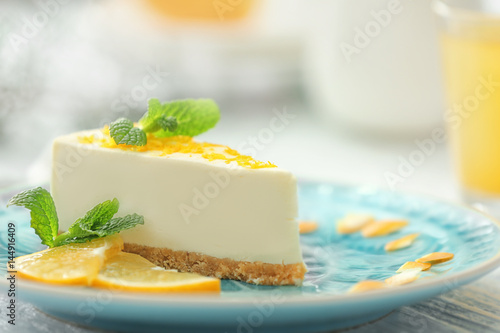 Tasty cheesecake slice with lemons on plate photo
