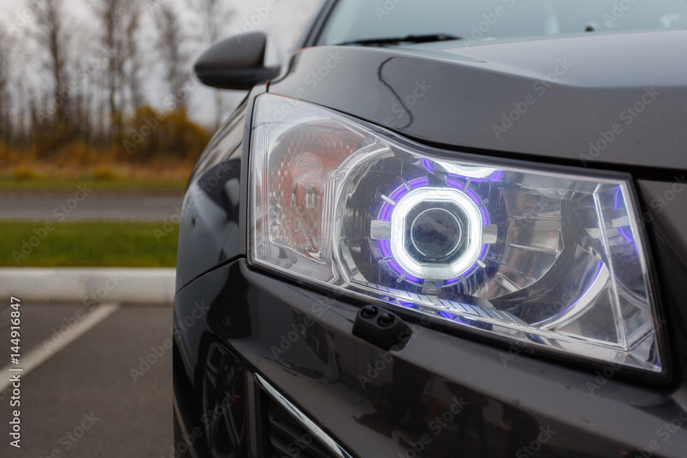 Closeup modern front a car headlight .