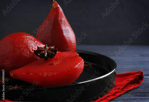 Pears poached in red wine as dessert on plate