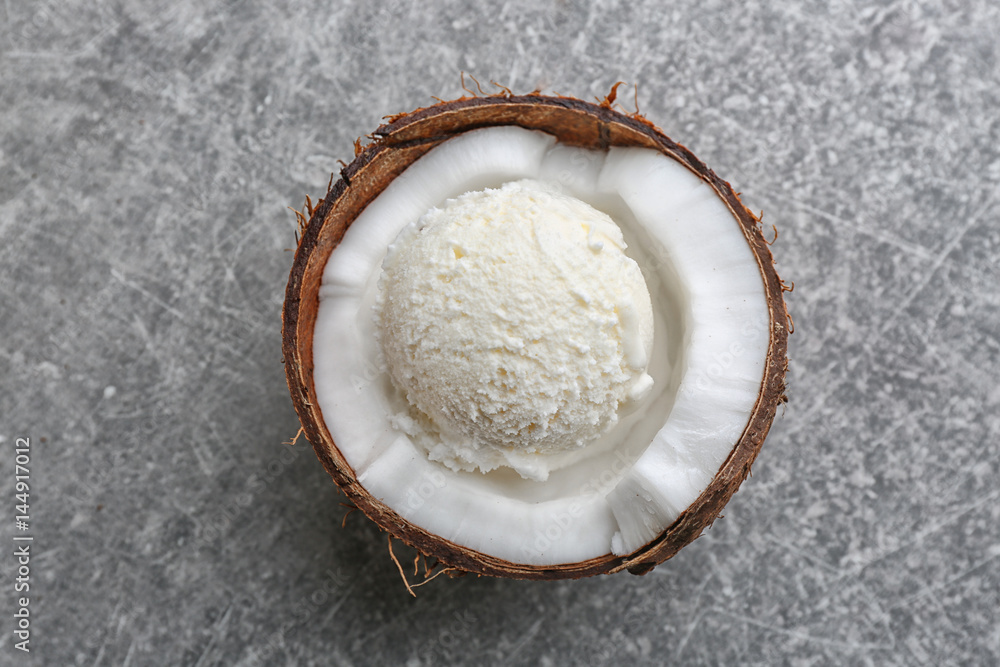 Fresh ball of ice cream in half of coconut on grey background Fresh ball of ice cream in half of coconut on grey background