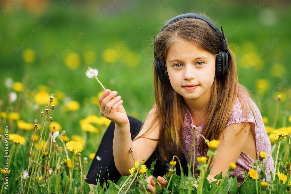 Cute little girl in headphones enjoying music in nature. Cute little girl in headphones enjoying music in nature.