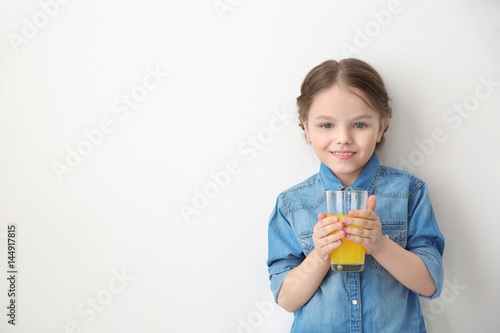 Cute little girl with glass of juice on white background