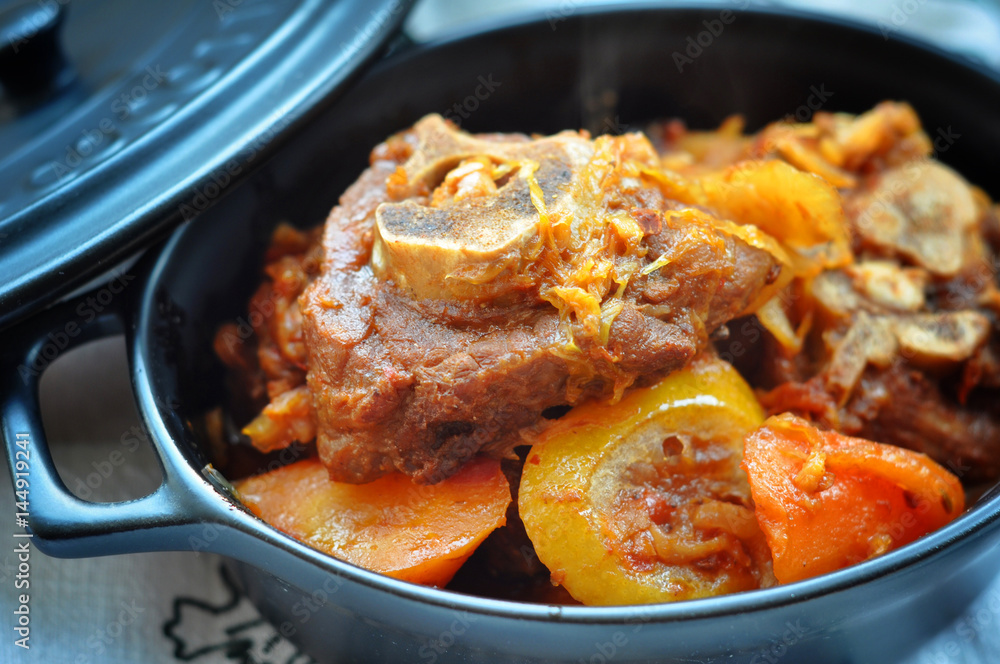 Fototapeta premium Sauteed beef ribs with potatoes in black pan