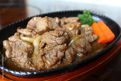 Sauteed beef with carrot on black platter