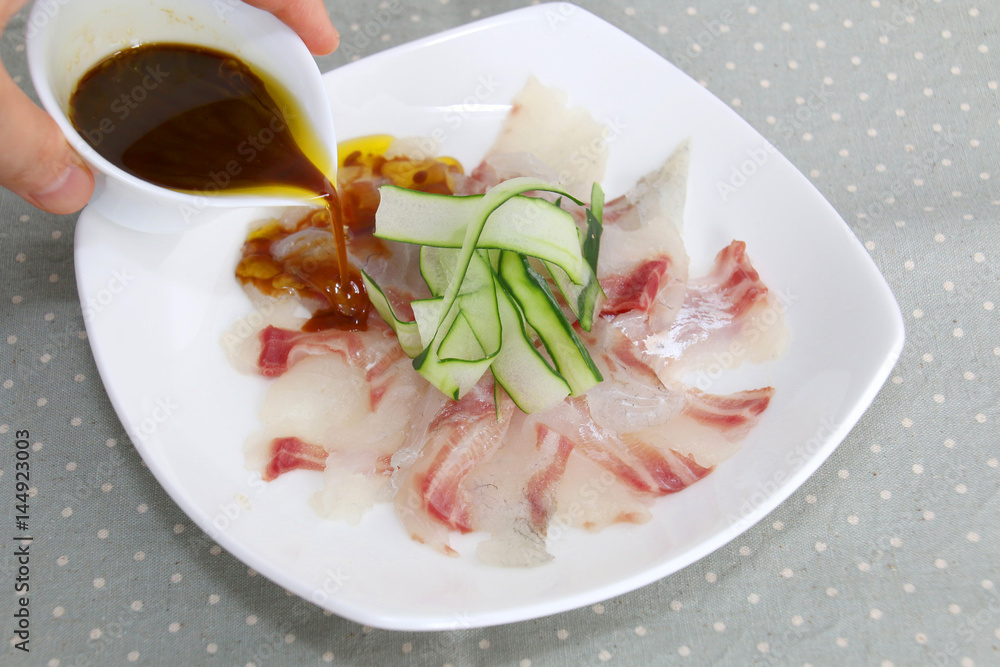 Fresh sashimi of fish with sauce on white platter Fresh sashimi of fish with sauce on white platter