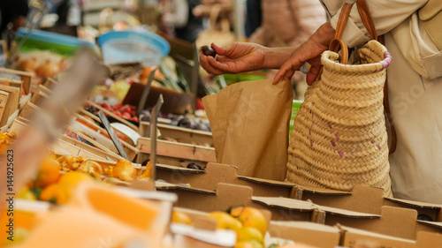 Girl picking out fresh produce at a market. Hands close-up.
