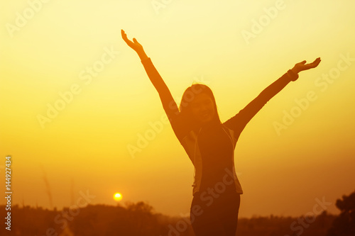 Happy woman raised hands up on the sky at sunset © Joelee Creative