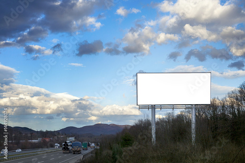 Blank white billboard on blue sky with the highway