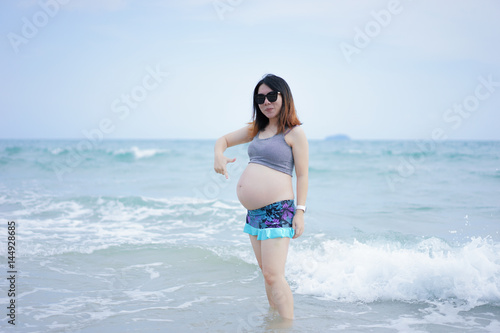 beautiful and happy pregnant woman stand in the beach