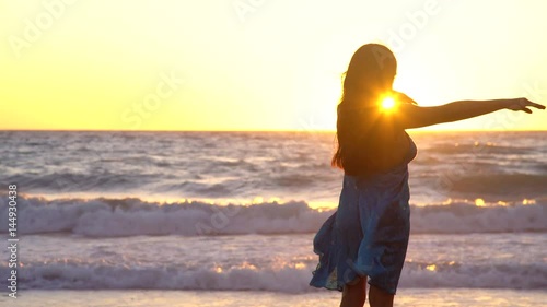 woman relaxing at a beach in her vacation in a sunset at a nice ocean photo