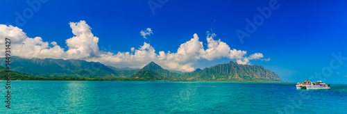 Panoramia of tropical lagoon, lush mountains, a catamaran and the ocean in Oahu, Hawaii