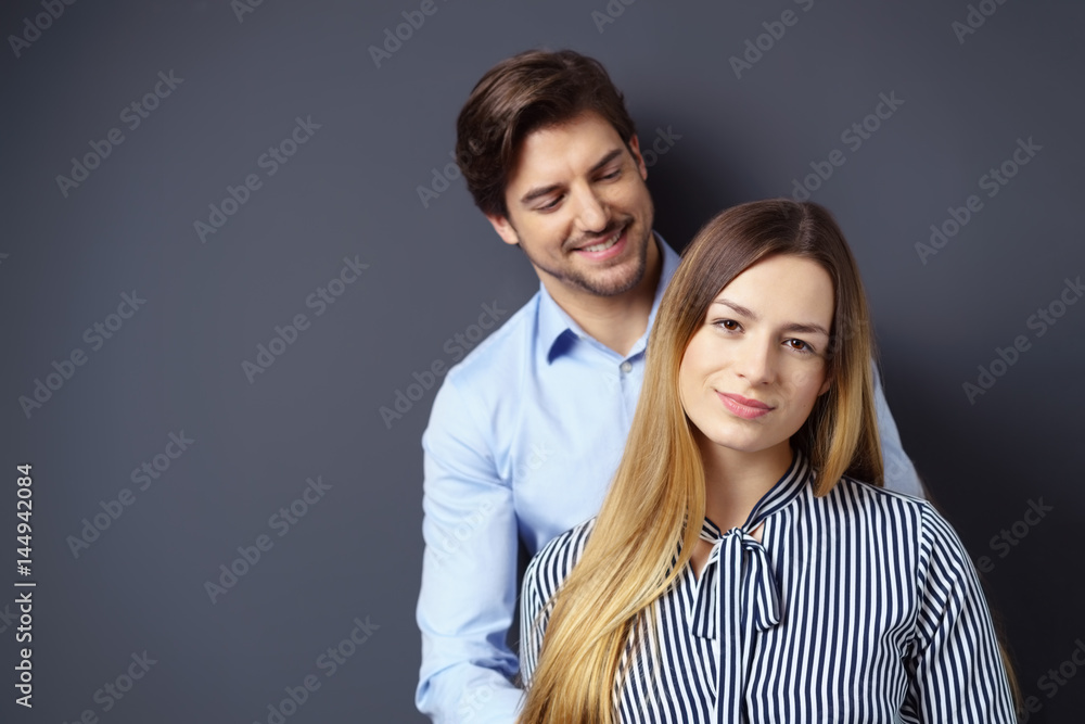 junges paar steht vor einer grauen wand junges paar steht vor einer grauen wand