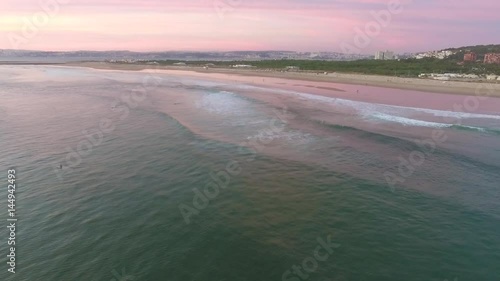 Aerial videoin motion during sunset in the Atlantic Ocean in Costa da Caparica, Lisbon, Portugal. photo