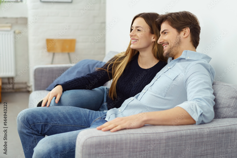 entspanntes paar sitzt auf dem sofa und schaut fern entspanntes paar sitzt auf dem sofa und schaut fern