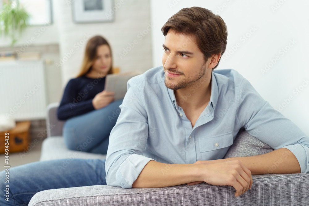 attraktiver mann sitzt entspannt zuhause auf der couch