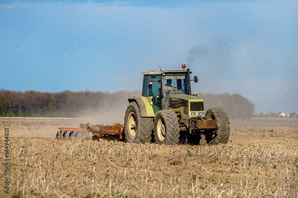 Obraz premium Tractor harrowing the land