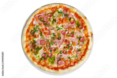 Top view of pizza with ham and sausage decorated with bell pepper and parsley