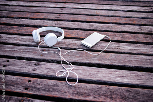 Wallpaper Mural Listen to music. White headphones and smartphone on wooden deck background. Torontodigital.ca