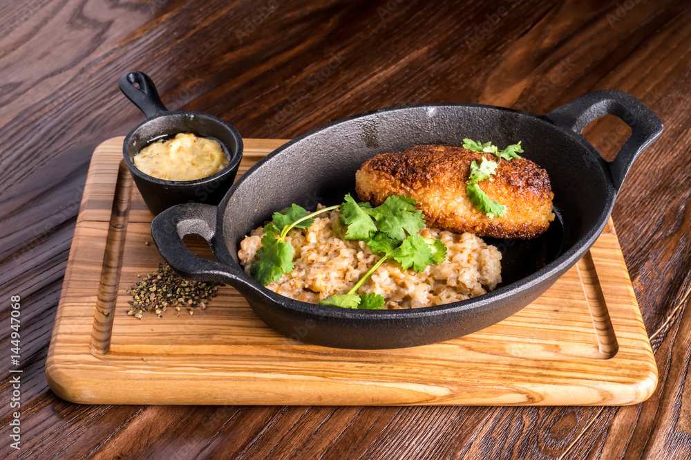 Buckwheat with patties in the frying pan on a wood Buckwheat with patties in the frying pan on a wood