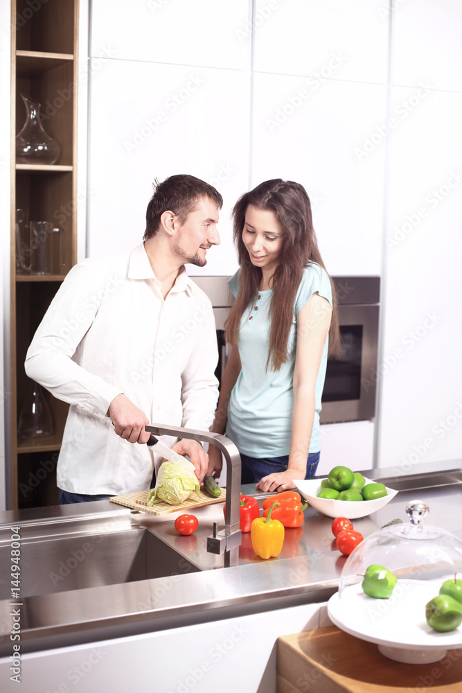 Portrait of happy young couple cooking together in the kitchen