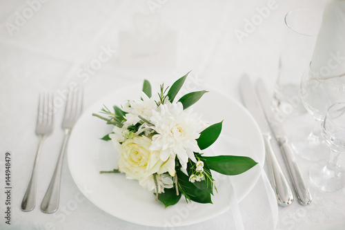 Served table with a plate, forks and flowers