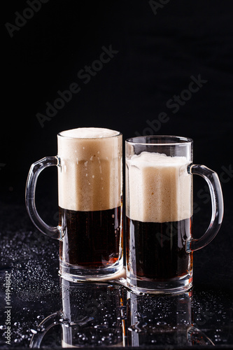Two mugs of foamy beer