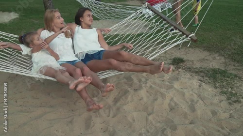 Happy mother with daughters rocking in hammock slow motion stock footage video photo