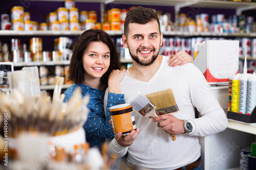 Couple purchasing tools for house improvements in paint supplies store