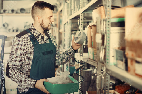 Man worker going through sanitary engineering details in worksho photo