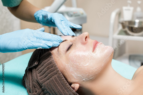 anti-aging facial massage. cosmetologist doing massage for young woman at Spa salon.
