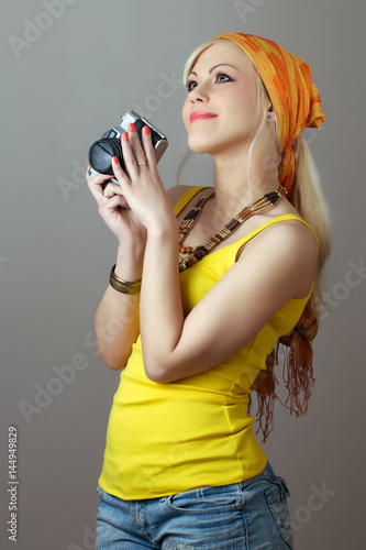 Beautiful blonde posing with retro photo camera