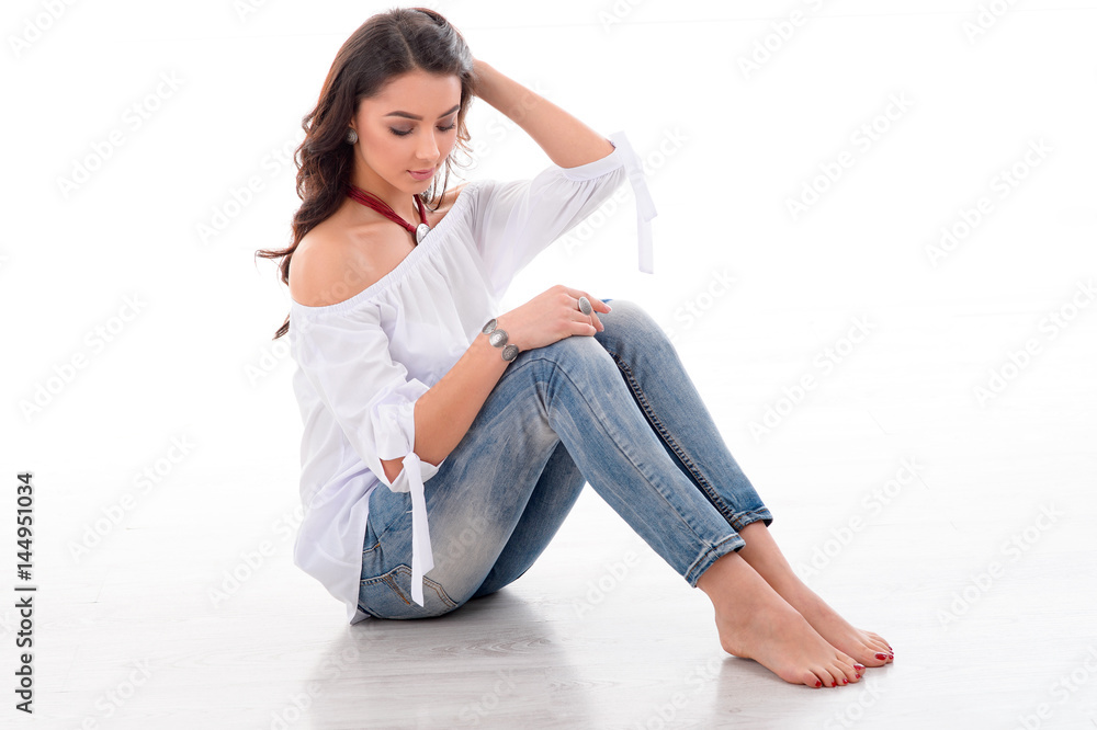 Beautiful young woman sitting on the floor with her long brown hair and demonstrated stylish jewelry and accessory. Beautiful young woman sitting on the floor with her long brown hair and demonstrated stylish jewelry and accessory.