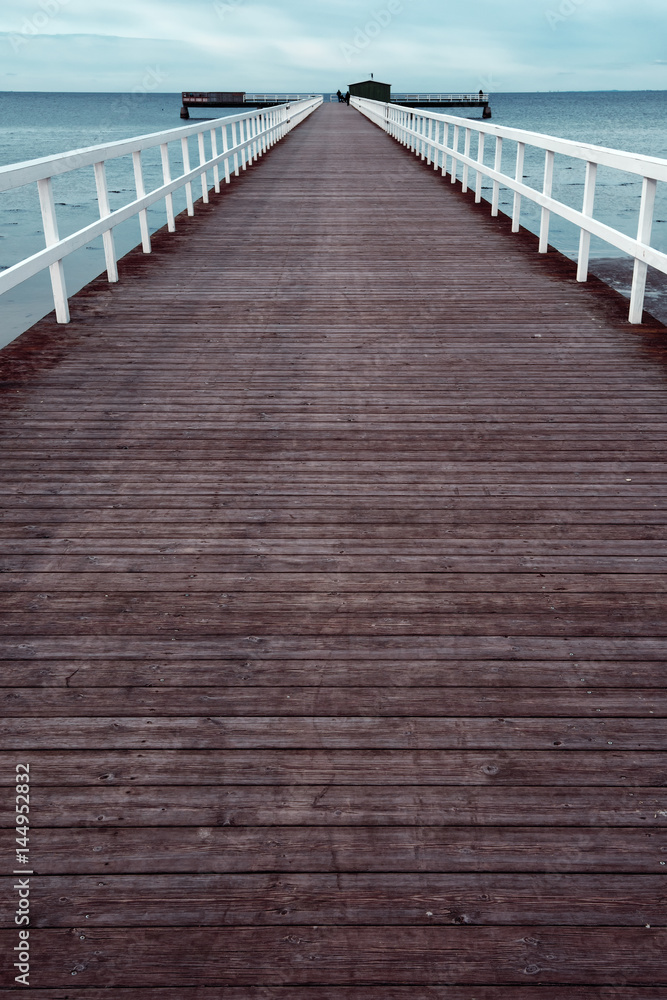 Empty wooden pier walkway on sea shore