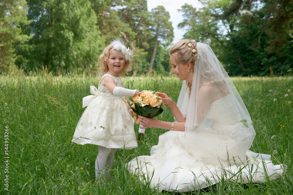 Mom Bride and her daughter together with a bouquet of the bride posing outdoors