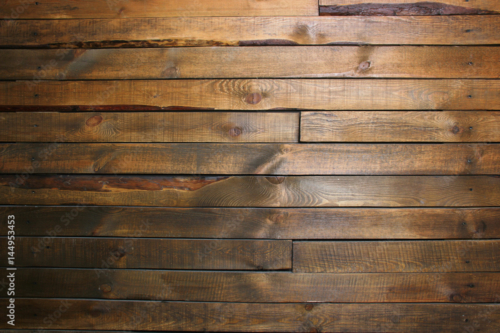 Naklejka premium Wall with dark brown wooden horizontal panels (pallets). Background
