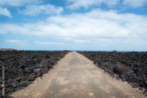 Track road among the rocks of lava in Timanfaya national park in Lanzarote, Canary Islands, Spain