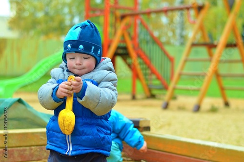 Little boy playing on a playground alone. Child concept. © Sasenki