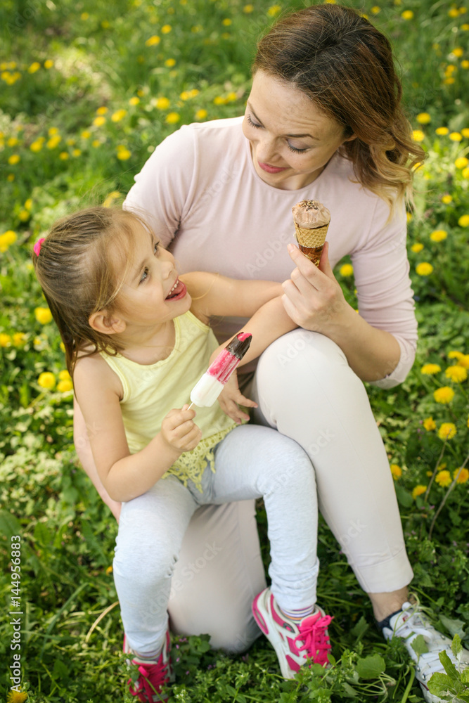 Mother and daughter sitting on the grass. Mother and daughter sitting on the grass.