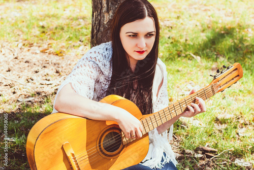 woman playing an acoustic guitar outdoor