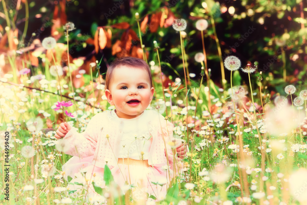 Beautiful baby girl among spring flowers