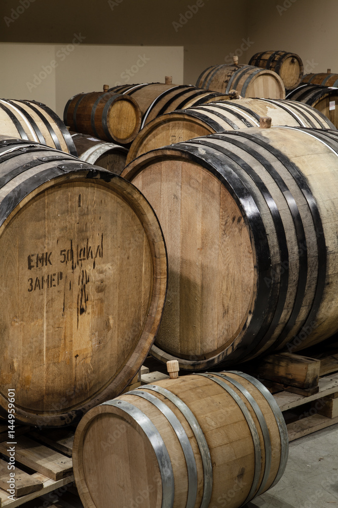 Old oak barrels in the cellar. Alcohol aging