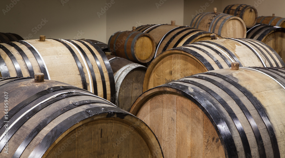 Old oak barrels in the cellar. Alcohol aging Old oak barrels in the cellar. Alcohol aging