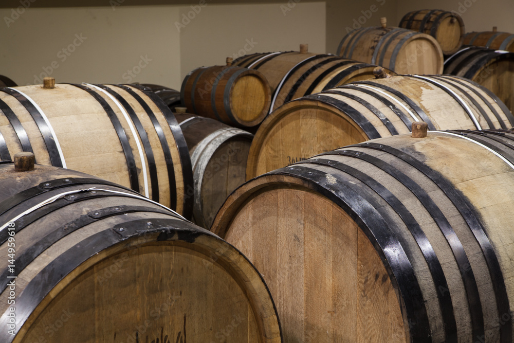 Old oak barrels in the cellar. Alcohol aging Old oak barrels in the cellar. Alcohol aging