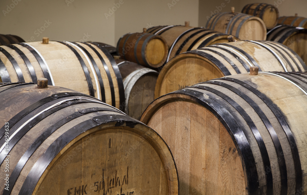 Old oak barrels in the cellar. Alcohol aging Old oak barrels in the cellar. Alcohol aging