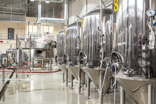 Brewery. Modern beer plant with brewering kettles, tubes and tanks made of stainless steel photo